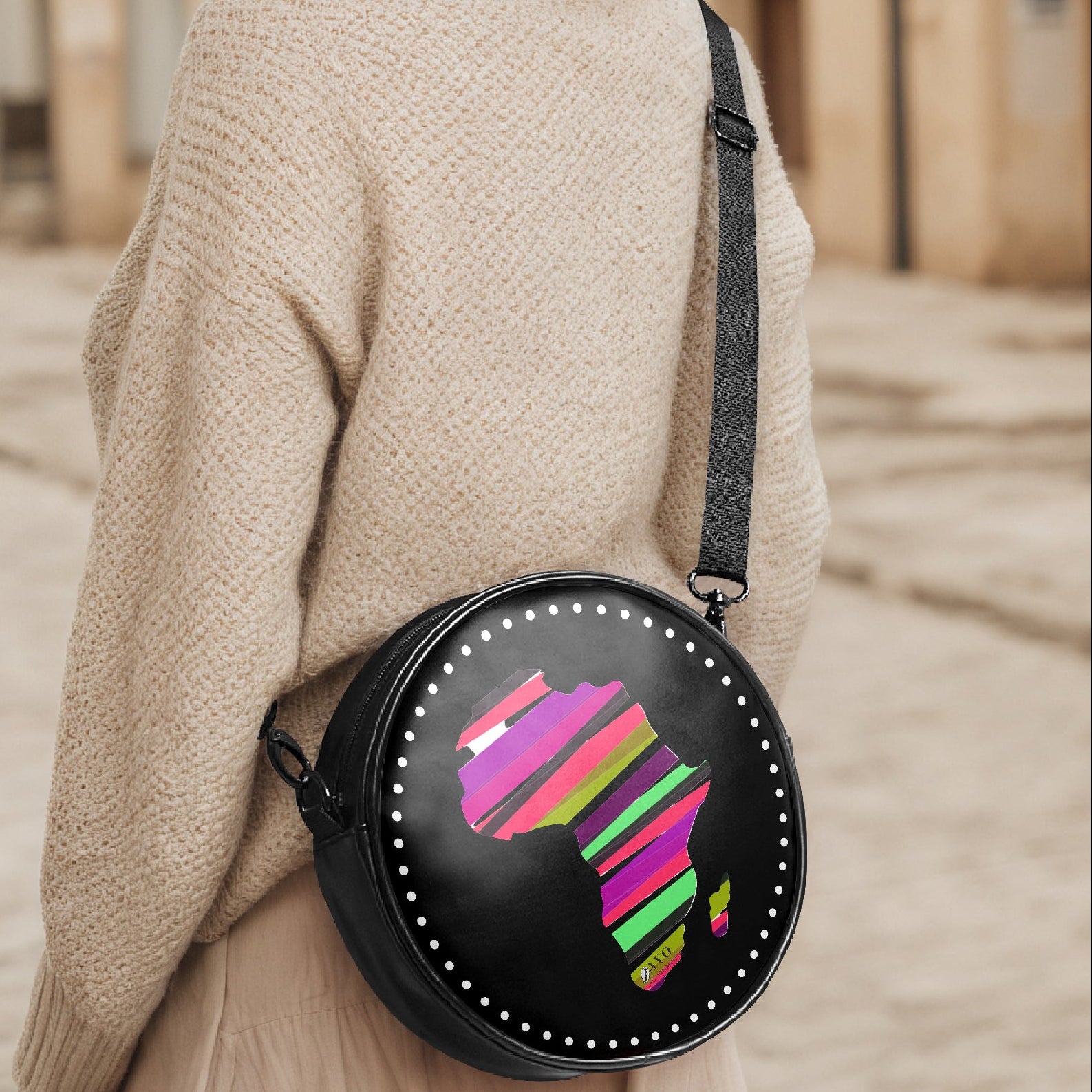 Person wearing a round bright and black Africa crossbody bag 